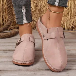 Macro view of stylish pink suede women clogs with adjustable metal buckle strap.
