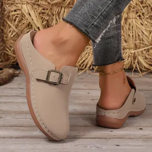Detailed close-up view of women's beige wedge clogs with a stylish metal buckle strap.