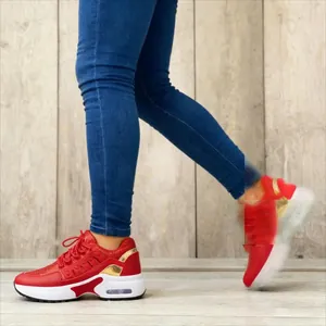 Nahaufnahme roter Fly-Knit-Sneaker mit Plateausohle am Bein eines Models im Detail
