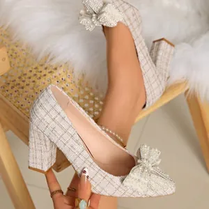 Close-up of elegant tweed chunky heel pumps with pearl bow detail