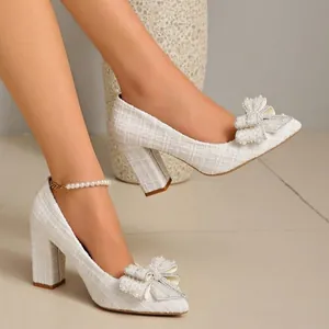 Elegant white tweed pumps featuring a chunky heel and exquisite pearl bow detail on pointed toe.