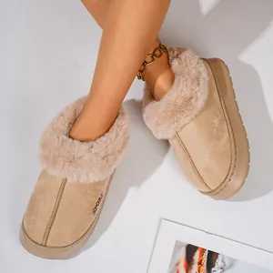 Close-up of stylish warm beige fleece-lined winter slippers for women with soft faux fur