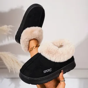 Close-up detail of black winter slippers with plush beige fur lining and thick soles
