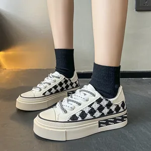 Nahaufnahme von schwarz-weißen Houndstooth-Canvas-Plateau-Sneakern mit dicken Sohlen