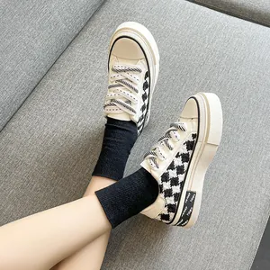 Detailansicht der karierten Plateau-Canvas-Sneaker mit schwarz-weißen Schnürsenkeln