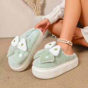 Vista dettagliata delle pantofole platform in peluche verde chiaro con cuori