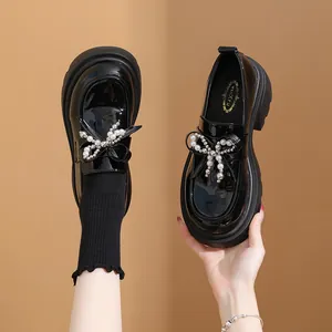 Κοντινή προβολή κομψών μαύρων λουστρίνι loafers με φιόγκο από πέρλες και πλατφόρμα