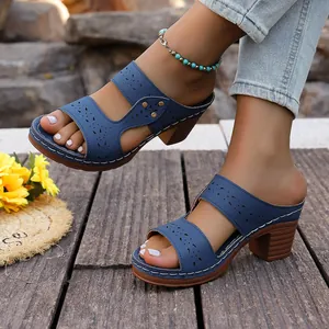 Detail of blue laser-cut chunky heel sandals worn with denim and an anklet.
