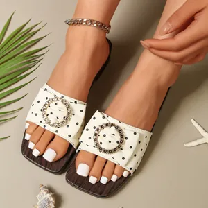 Close-up of vintage polka dot sandals with gold metal buckle and wood grain sole