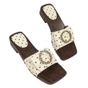 Vintage polka dot slide sandals with crystal buckle and wood grain platform heel.