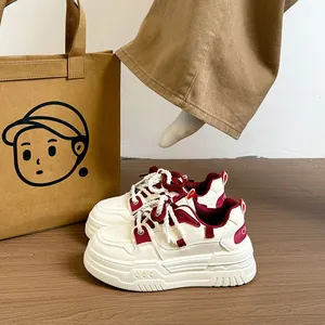Gros plan de baskets compensées blanches et bordeaux élégantes avec des lacets épais
