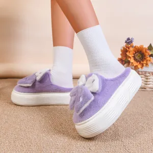 Vista dettagliata di ciabatte in peluche viola con suola spessa e design a orecchie di coniglio