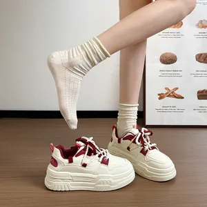 Vue détaillée de baskets à plateforme blanc cassé avec accents bordeaux et lacets de style corde