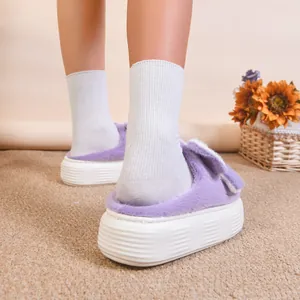 Dettaglio laterale di pantofole in peluche viola con orecchie di coniglio e suola spessa
