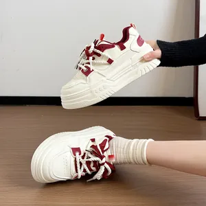 Vue détaillée des baskets compensées crème avec touches rouges et lacets en corde.