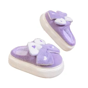 Simpatiche pantofole platform viola con grandi fiocchi decorativi e spesse suole bianche.