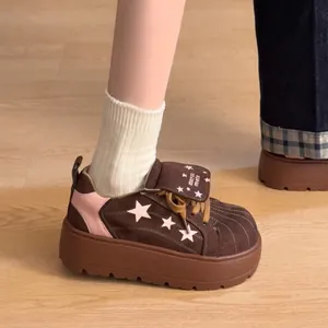 Primer plano de zapatillas de plataforma marrones con patrón de estrellas y rosa