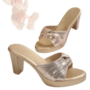 Elegantes sandalias de plataforma doradas con tacón grueso y tiras de tela anudadas.