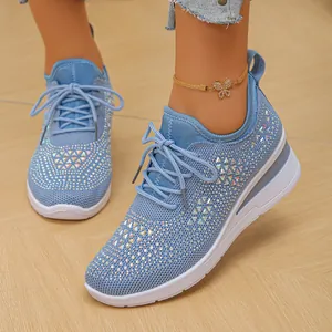 Primer plano de zapatillas azules de plataforma con diamantes de imitación y cordones.