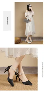 Close-up of elegant black pointed-toe pumps with pearl ankle straps and bow detail