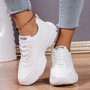 Detailed macro view of women's trendy white chunky platform sneakers with lace-up design