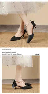 Detail view of elegant black pointed-toe high heels with pearl ankle straps and bow.
