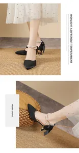 Detailed view of elegant black pointed-toe high heels with pearl ankle straps and bow