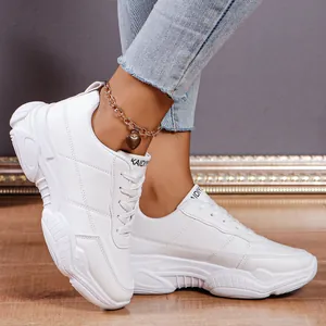 Detail shot of stylish white chunky sneakers with lace-up design for women