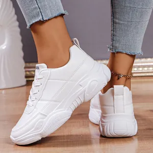 Detailed view of stylish white platform sneakers with lace-up design for women.