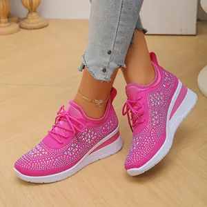 Primer plano de zapatillas con cuña rosas y diamantes en tejido fly-knit transpirable.
