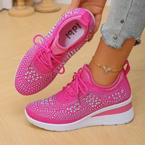 Primer plano de zapatillas de cuña de punto rosa con detalles de pedrería y cordones suaves.