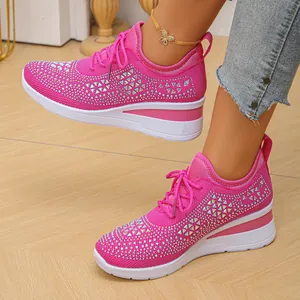 Vista detallada de zapatillas de punto rosa transpirable con pedrería y suela de cuña