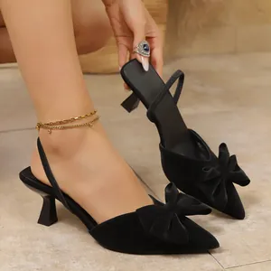 Detailed view of black pointed toe kitten heels with elegant bow and slingback strap.