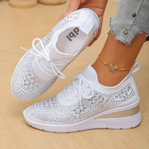 Primer plano de zapatillas blancas de cuña de punto con detalles de pedrería