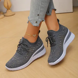Detalle de zapatillas de cuña tejidas en gris para mujer con adornos de pedrería y cordones
