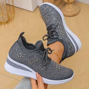 Primer plano de zapatillas grises de cuña tejidas transpirables con detalles de strass.