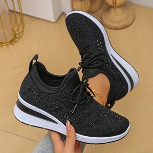 Primer plano de zapatillas negras de cuña en tejido fly-knit con pedrería