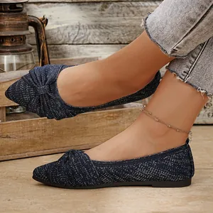 Nahaufnahme von dunkelblauen Strick-Ballerinas mit Schleife und Glitzereffekt