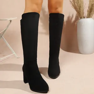 Black faux suede knee-high boots featuring a stylish chunky heel and slimming silhouette