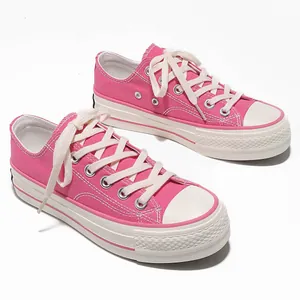 Sneakers basse in tela rosa con suole platform bianche spesse e lacci piatti alla moda