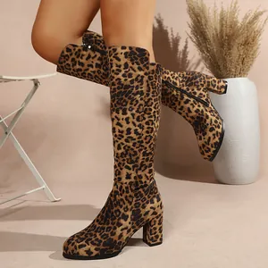 Close-up detail of leopard print suede knee high boots featuring a chunky high heel