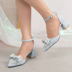 Detailed view of light blue tweed block heels with pearl-beaded bow and ankle strap