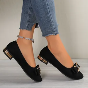 Elegant black pointed toe flat shoes with rhinestone bow detail and low gold heel