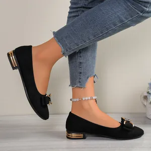 Detailed view of black pointed-toe flats featuring a rhinestone bow and metallic heel.