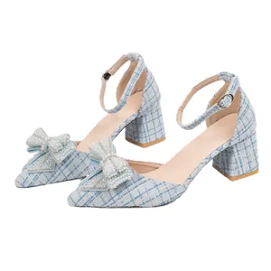 Elegant light blue tweed chunky heel pumps with pearl bow and adjustable ankle strap.