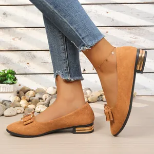 Detail of brown pointed toe low heel shoes with rhinestone bow decoration
