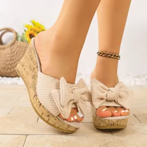 Vista dettagliata di sandali con zeppa beige da donna con fiocco e suola in sughero