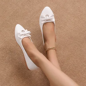 Detailed view of white pointed-toe flat shoes for women with elegant bow decoration