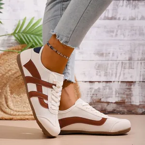 Side view of women's retro German Trainer sneakers in cream-white with brown stripes