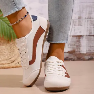 Detailed close-up view of stylish retro cream sneakers for women with brown wave patterns
